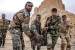 Бойцы сирийской армии несут раненого у подножия замка Фахр ад-Дина