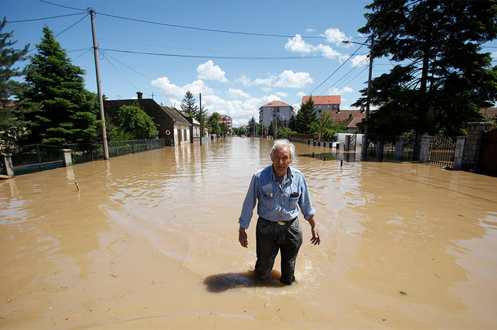 Местный житель идет по&nbsp;затопленному в&nbsp;результате наводнения городу Обреновац
