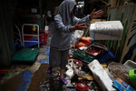 Владелец убирает мусор из своего ресторана, пострадавшего от наводнения после проливного дождя, на рынке в Сеуле, Южная Корея, 9 августа 2022 года