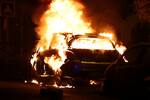 Горящий автомобиль во время беспорядков после гибели 17-летнего подростка в Нантере, Франция, 28 июня 2023 года
