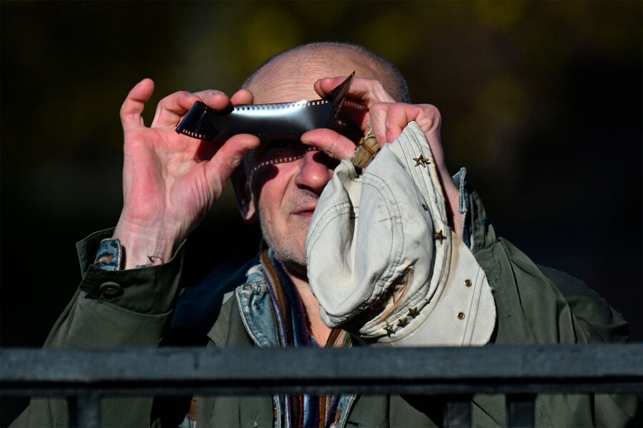 Мужчина наблюдает через&nbsp;фотопленку частичное солнечное затмение в&nbsp;Москве, 25&nbsp;октября 2022&nbsp;года