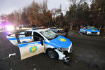 Поврежденные полицейские автомобили возле мэрии во время акций протеста в Алматы, Казахстан, 5 января 2022 года
