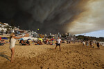 Отдыхающие играют на пляже на фоне дыма от лесных пожаров в Винья-дель-Мар, Чили, 2 февраля 2024 года