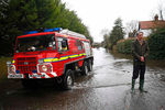 Министр обороны Великобритании Филип Хаммонд общается с прессой на затопленной улице в городке Рейсбери на юге Англии