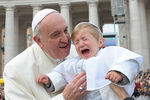 Папа Римский Франциск благословляет ребенка на площади Святого Петра в Ватикане