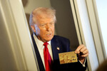 Президент США Дональд Трамп демонстрирует журналистам «золотую» карту, которая даст возможность получить гражданство США за 5 млн долларов, на борту самолета Air Force One, летящего в Майами, 3 апреля 2025 года