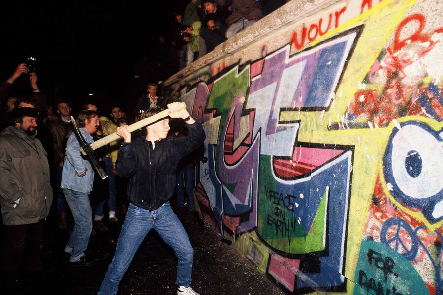 Люди участвуют в разрушении Берлинской стены со стороны Западного Берлина, 10 ноября 1989 года