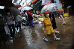 Люди идут по дороге, затопленной после проливного дождя, на рынке в Сеуле, Южная Корея, 9 августа 2022 года