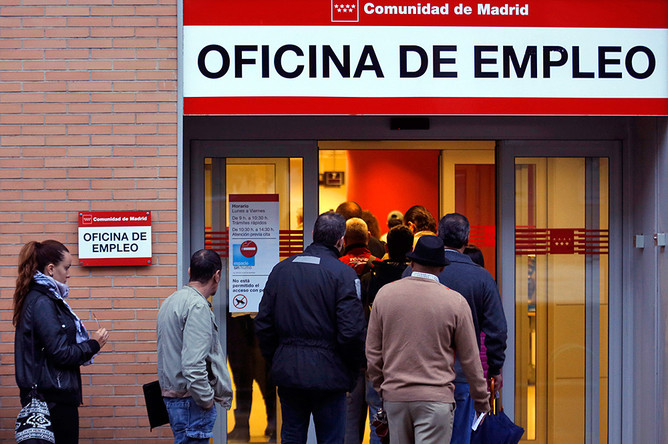 Люди стоят в очереди в бюро по трудоустройству в Мадриде
