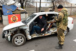 Ополченец разговаривает с водителем автомобиля на блокпосту ДНР в Киевском районе Донецка