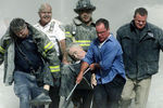 Спасатели несут мужчину, раненого во время теракта в Нью-Йорке, 11 сентября 2001 года