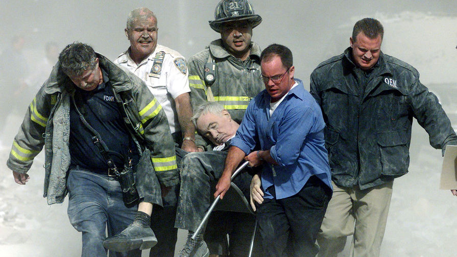 Спасатели несут мужчину, раненого во время теракта в Нью-Йорке, 11 сентября 2001 года