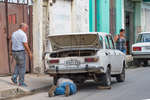 A man fixes a Moskvich car on a street in Havana, Cuba, 2015