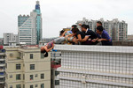 14 августа. Родственники и спасатели держат женщину, пытавшуюся спрыгнуть с крыши здания в Джандзяне, провинция Гуандунь. Женщина пыталась покончить с собой из-за убийства племянника в ходе семейной ссоры. 