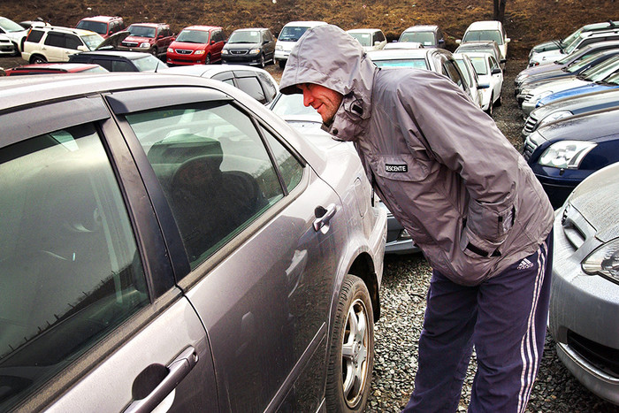 Покупатель во время осмотра автомобилей, выставленных на продажу