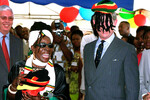 Принц Чарльз на Ямайке примеряет традиционный головной убор растаманов, 2000 год
