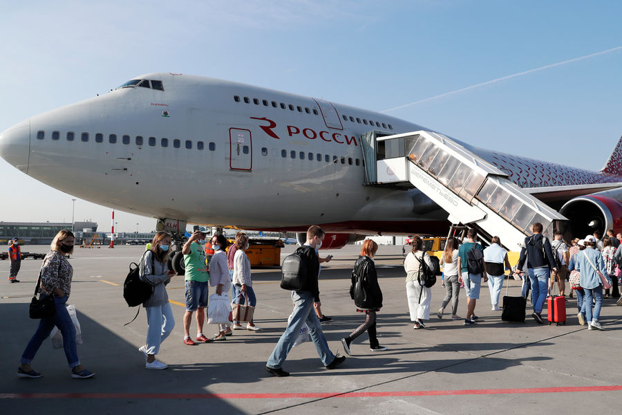 Пассажиры во время посадки на самолет Boeing 747-400 авиакомпании «Россия», следующий в Шарм-эш-Шейх, в международном аэропорту Шереметьево, 9 августа 2021 года 