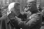 Советский солдат оказывает медицинскую помощь раненому местному жителю, Берлин, май 1945 года