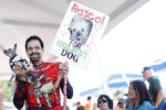 Эндрю Дейн из Саннивейла, штат Калифорния, несет Рэскала, китайскую хохлатую собаку, по красной ковровой дорожке