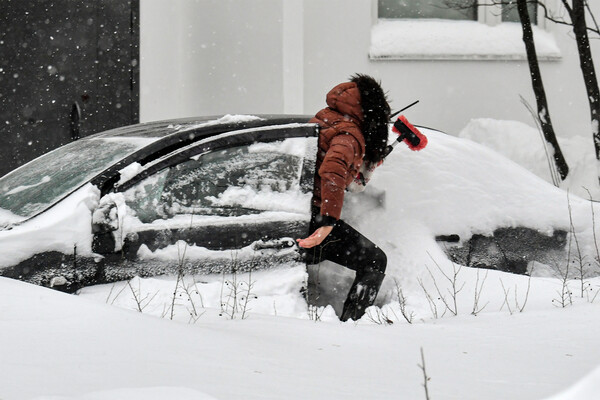 Женщина чистит от снега автомобиль, Москва, 18&nbsp;декабря 2022&nbsp;года