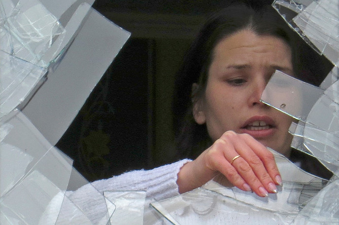 Медработница разбирает завалы в кабинете 27-й больницы, где в результате попадания снаряда пять человек погибли