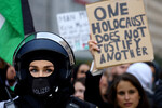Девушка держит в руках табличку с надписью «Один Холокост не оправдывает другой» во время пропалестинского протеста во Франкфурте, Германия, 18 октября 2023 года