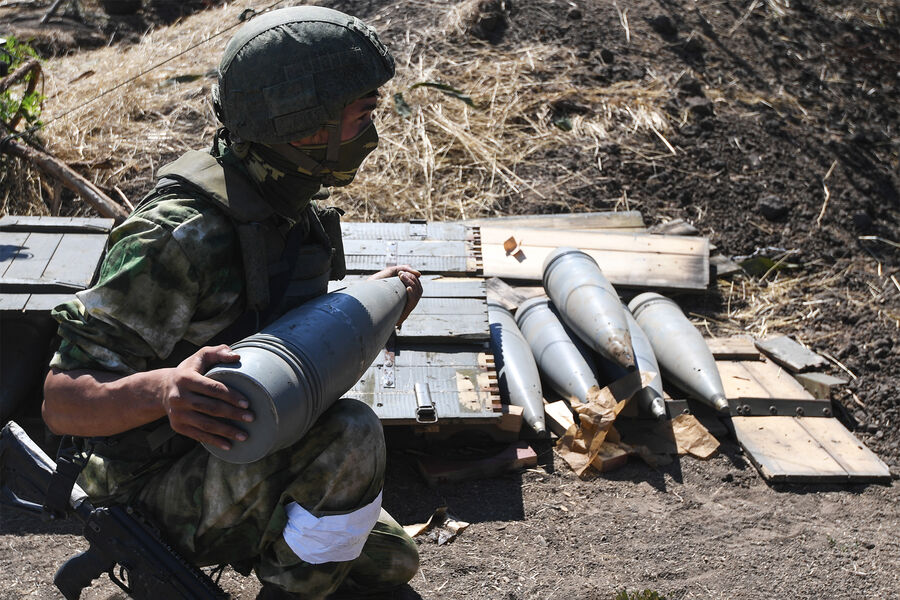 Военнослужащий гаубичной батареи воздушно-десантных войск Вооруженных сил РФ несет снаряд к гаубице на позициях на южном направлении специальной военной операции на Украине