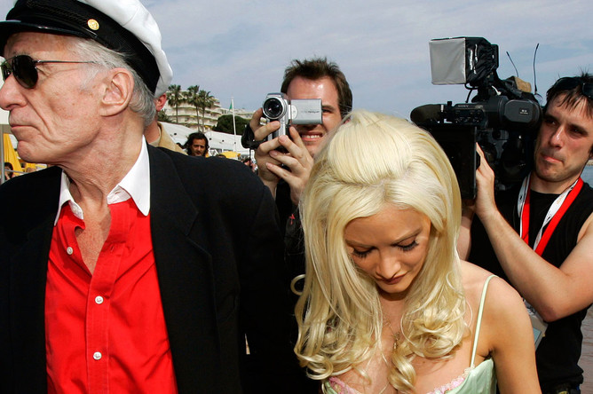 Основатель журнала Playboy Хью Хефнер с подругой Холли Мэдисон прогуливаются по пляжу во время 59-го Каннского кинофестиваля, 2006 год