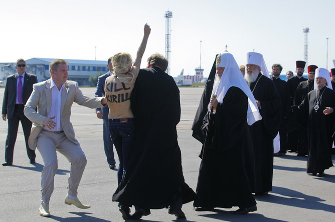 Активистка движения «Фемен» в аэропорту Борисполь во время акции протестует против приезда патриарха Московского и всея Руси Кирилла в Киев. 26 июля 2013 года