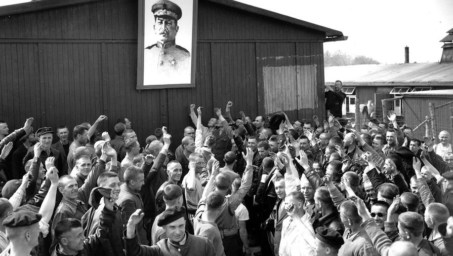 Русские военнопленные, освобожденные армией США, приветствуют портрет Иосифа Сталина в&nbsp;нацистском лагере для&nbsp;военнопленных Бухенвальд, апрель 1945 года
