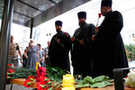 Священнослужители возлагают цветы к месту гибели людей в результате взрыва автобуса в Воронеже, 13 августа 2021 года