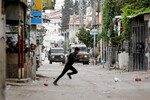 Палестинец убегает от столкновения с израильскими войсками во время рейда в Наблусе, 13 июня 2023 года