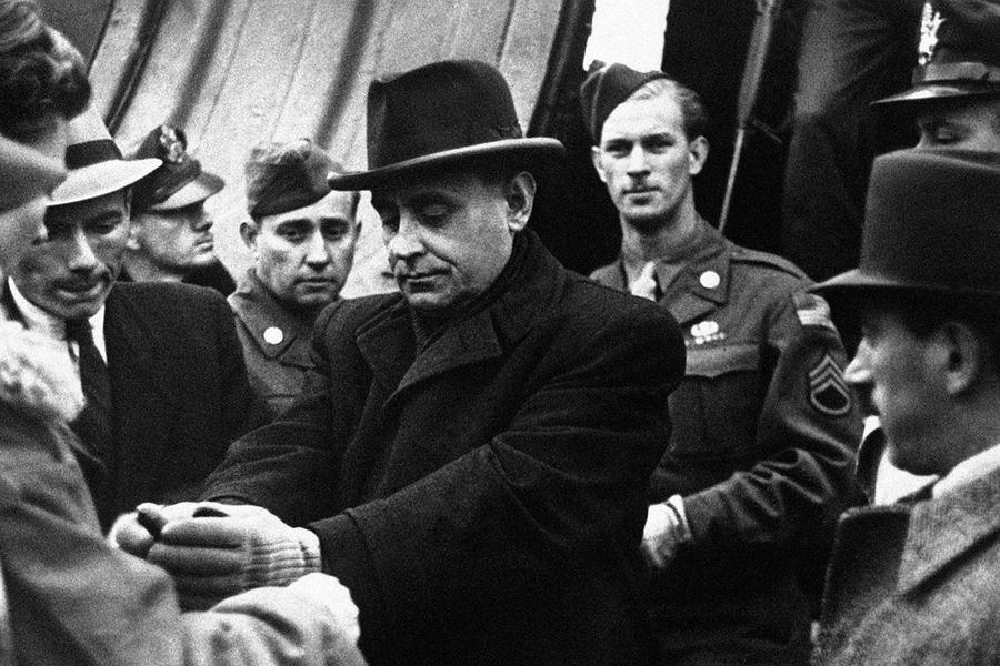 Венгерский полицейский надевает наручники на Ференца Салаши при выходе из самолета в аэропорту Будапешта, 5 октября 1945 года