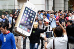 Человек в маске основателя компании Apple Стива Джобса держит картонный макет нового IPhone 6 в очереди в токийском Apple Store