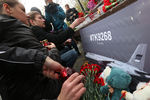 Цветы и свечи у памятника пограничникам Отечества на площади Яузских ворот в память о жертвах авиакатастрофы самолета Airbus A321
