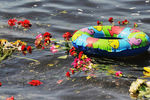 Цветы и детский надувной круг в реке Волге в казанском речном порту во время гражданской акции в память о погибших на теплоходе «Булгария», 12 июля 2011 года