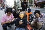 Человек в маске Стива Джобса в очереди у магазина Apple в Токио