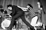 Музыкант Джон Леннон на сцене убегает от фаната во время концерта The Beatles в Риме, Италия, 28 июня 1965 года