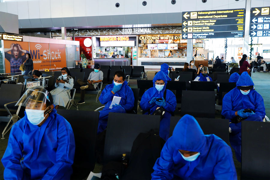 Посетители аэропорта Сукарно-Хатта в защитных костюмах, Тангеран, Индонезия, 2021 год