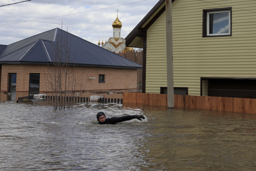 Местный житель плывет по&nbsp;затопленной улице в&nbsp;Оренбурге, 13&nbsp;апреля 2024&nbsp;года
