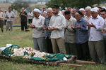 Люди молятся на похоронах Натальи Эстемировой в Грозном, 16 июля 2009 года 