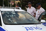 Сотрудники правоохранительных органов у автомобиля ДПС, обстрелянного злоумышленником в Краснодаре