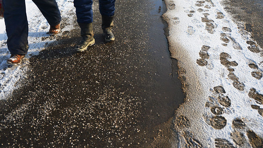 Тротуар, посыпанный противогололедным реагентом после сильного снегопада в Москве