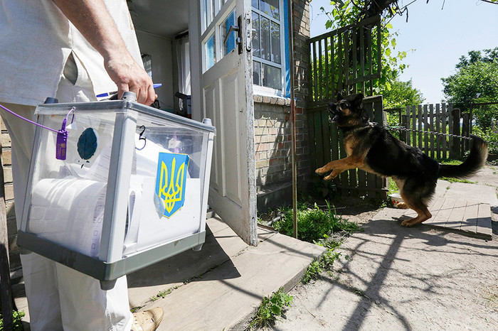 Член избирательной комиссии несет мобильную урну в&nbsp;селе Забуянье, Киевская область