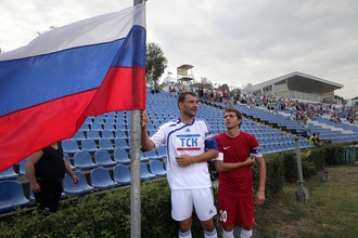 Футболисты поднимают российский флаг перед началом матча 1/256 финала Кубка России по футболу между ТСК (Симферополь) и СКЧФ (Севастополь)