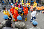 Спасатели выносят из шахты пострадавшего в результате взрыва шахтера