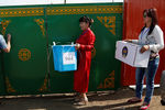 Члены избирательной комиссии несут урну для голосования по открепительным удостоверениям в один из домов в Монголии