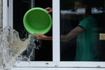 Юноша вычерпывает воду из своей квартиры на затопленной улице Уссурийска