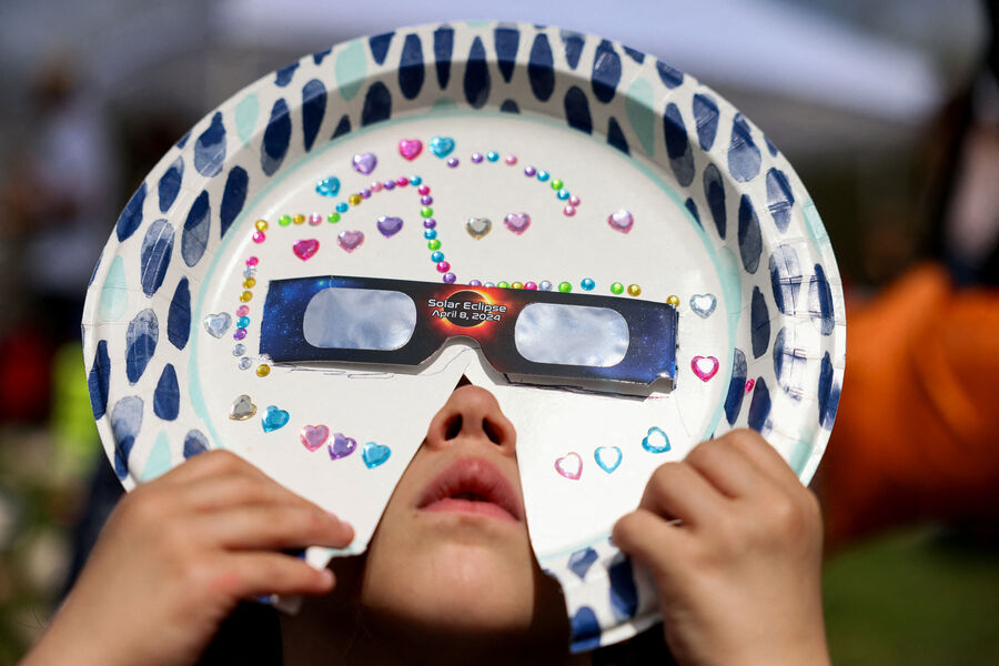 Ребенок наблюдает за&nbsp;частичным солнечным затмением с&nbsp;помощью самодельной маски в&nbsp;Нью-Йоркском зале науки в&nbsp;районе Квинс, Нью-Йорк, США, 8&nbsp;апреля 2024&nbsp;года 