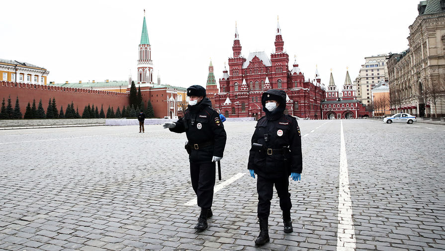 Сотрудники полиции на опустевшей Красной площади в Москве, 30 марта 2020 года